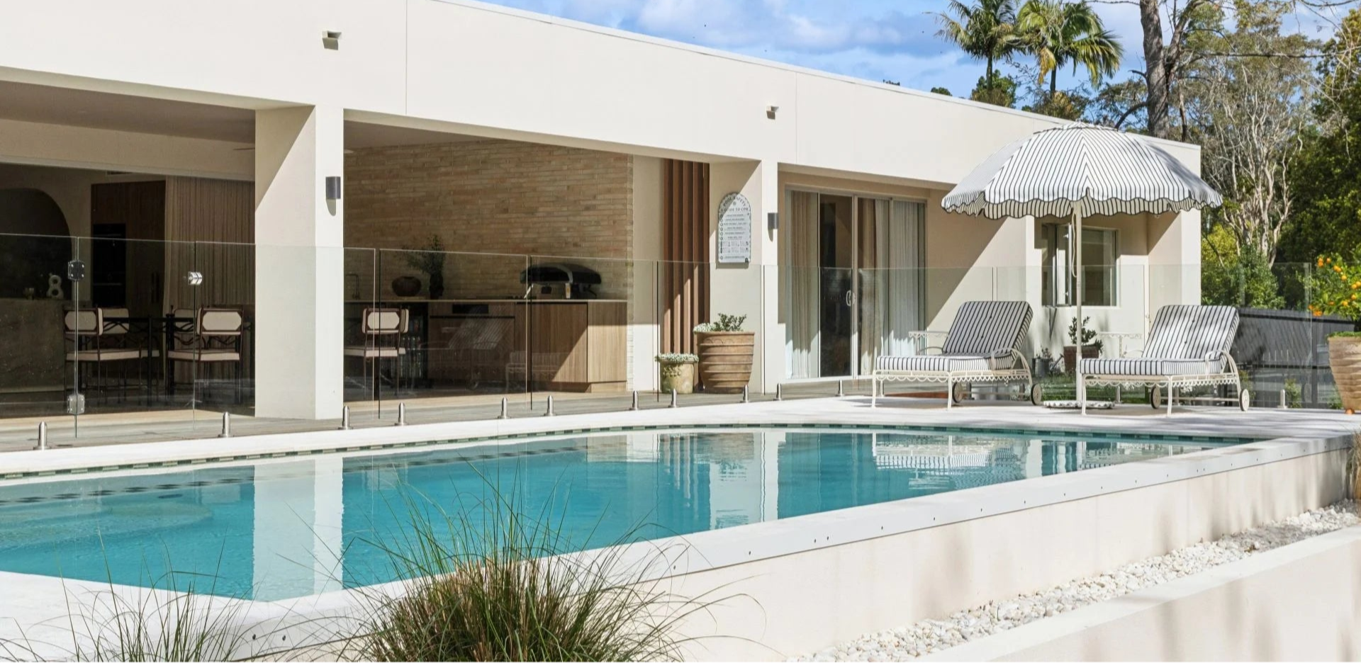 Modern house with a pool and outdoor furniture under a clear blue sky.