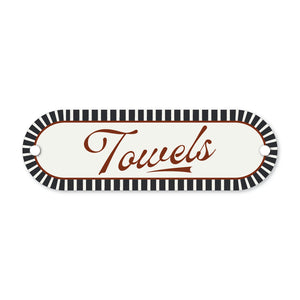 Decorative sign with 'Towels' text and black and white striped border on a white background